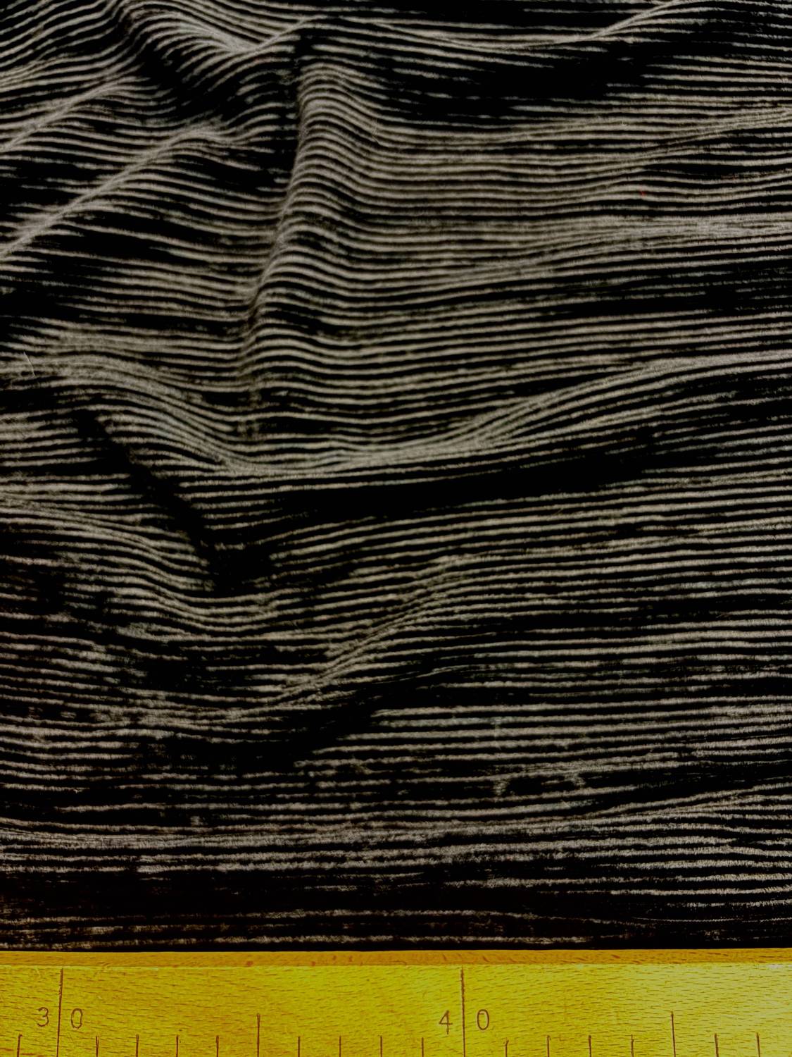 Fekete gyűrt, bordázott hatású elasztikus anyag